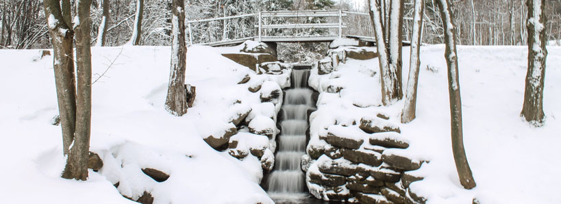 Small waterfall with a bridge over it.